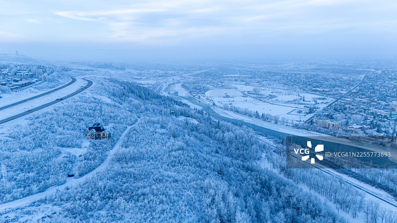 加拿大阿尔伯塔省卡尔加里市中心附近，弓河与被雪覆盖的森林的空中冬季景观图片素材
