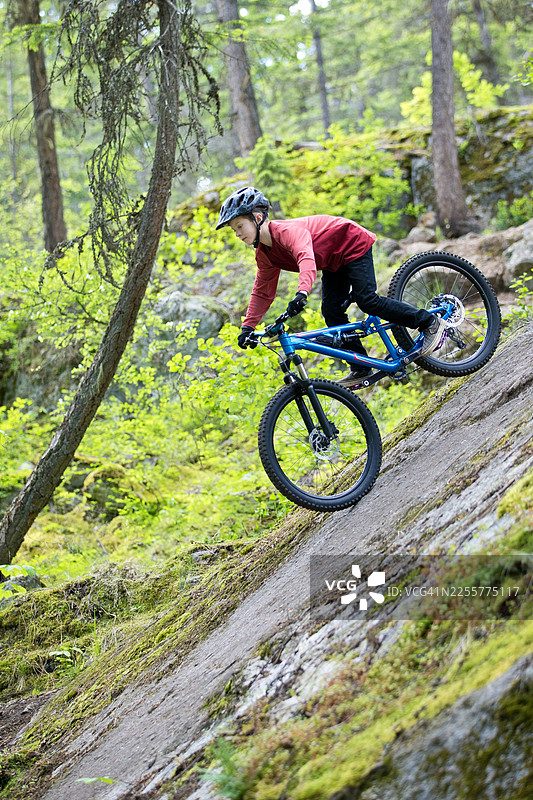 专业山地自行车男孩骑行下岩石图片素材