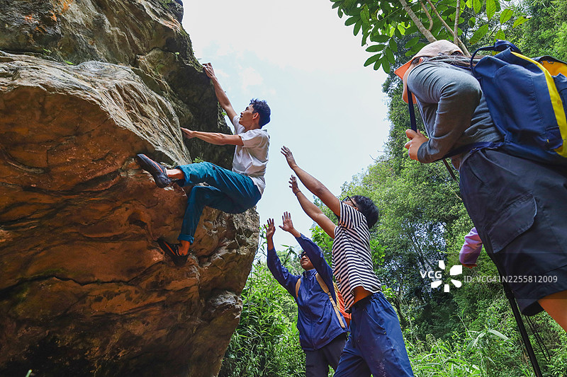 朋友们支持的男性攀岩者图片素材