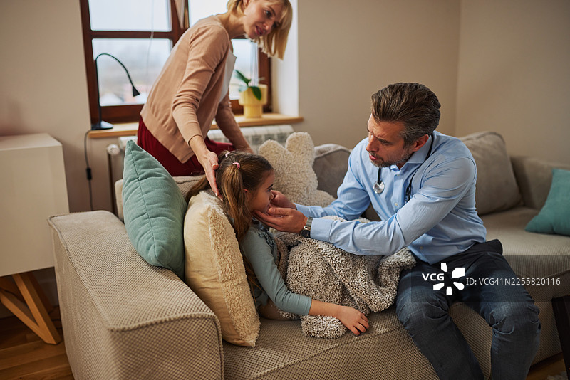 医生在家探望女孩，客厅沙发上的温馨家庭时刻图片素材
