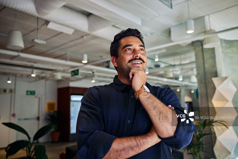 面带微笑的男士在现代创业公司办公室工作图片素材