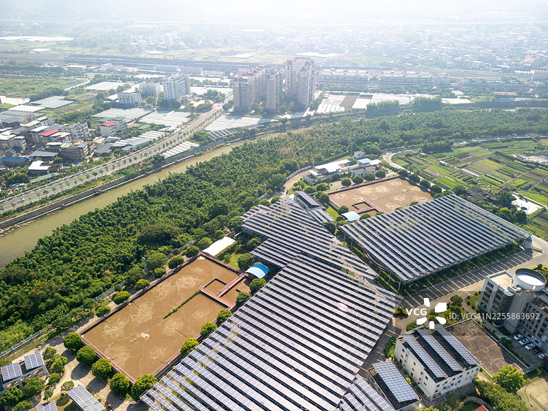 污水处理厂太阳能电池板和城市景观的鸟瞰图图片素材