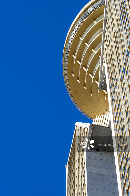 从低角度拍摄的西班牙贝尼多姆英特波双塔及其上层结构的细节，背景是湛蓝的天空图片素材