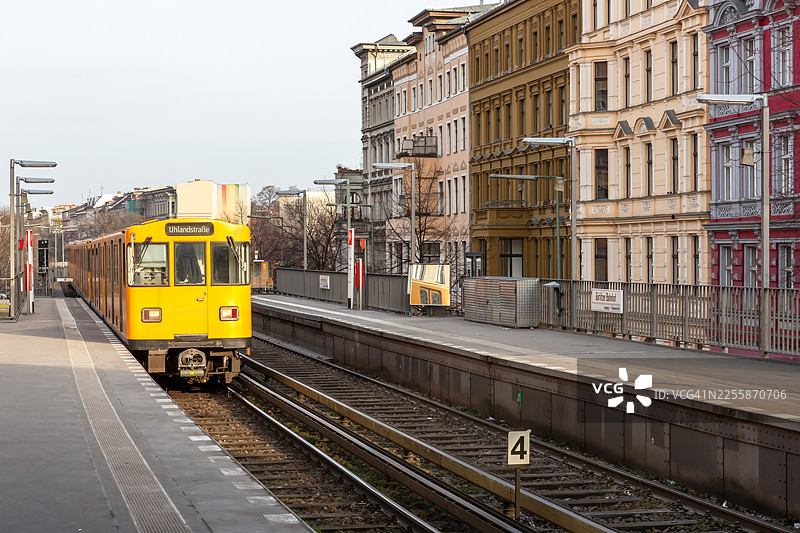 地铁列车抵达车站，背景是历史悠久的住宅建筑外墙图片素材