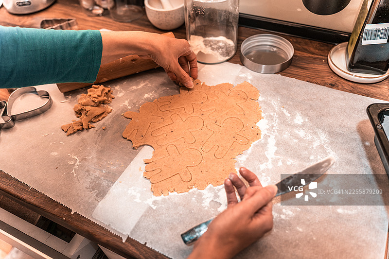 姜饼面团在厨房台面上准备，配有饼干模具，供节日烘焙和庆祝活动使用图片素材