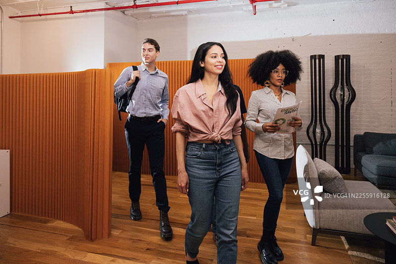 同事们在现代办公室里走动并互相问好图片素材