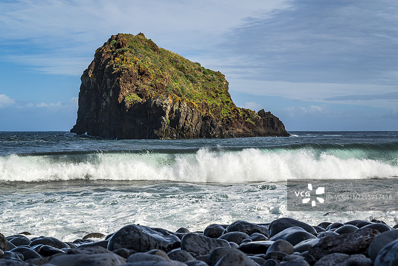 葡萄牙马德拉岛Ilhéu da Ribeira da Janela的黑色岩石景观,可俯瞰海浪和翻滚的海浪图片素材