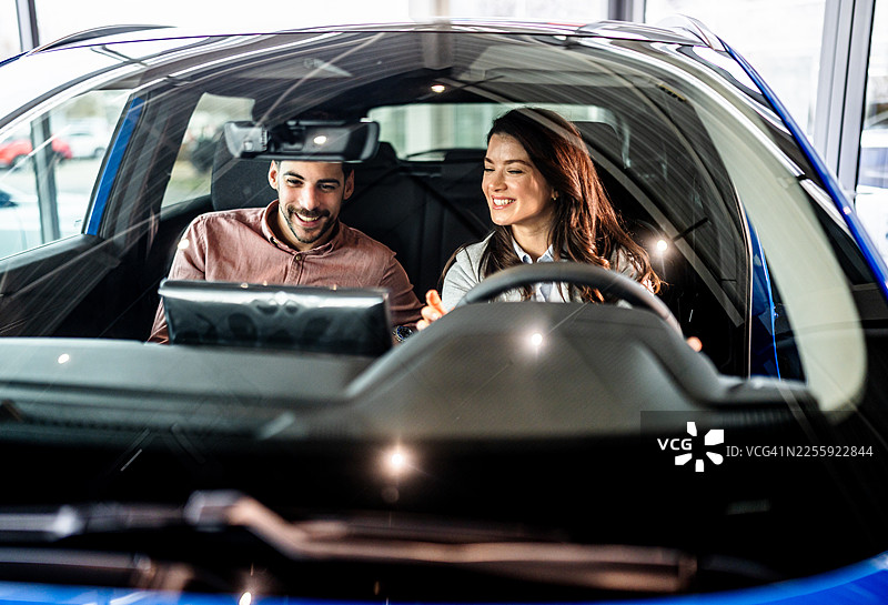 一对夫妇在汽车经销商展厅购买新车图片素材