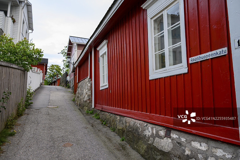 芬兰西南芬兰地区那坦利老城区的街道景象,一条小巷坐落着红色的木制建筑和白色的窗户。迷人的乡村城镇景观,那坦利,芬兰西南芬兰地区,芬兰图片素材