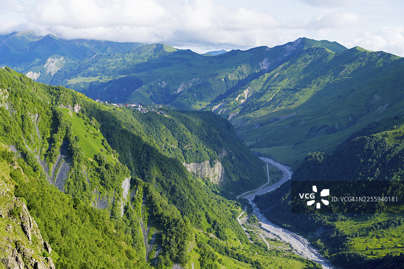 绿色高山景观，有蜿蜒的河流和背景中雄伟的山脉，格鲁吉亚姆茨赫塔-姆蒂亚涅蒂地区古道里附近的风景，阿拉格维河，高加索，格鲁吉亚图片素材
