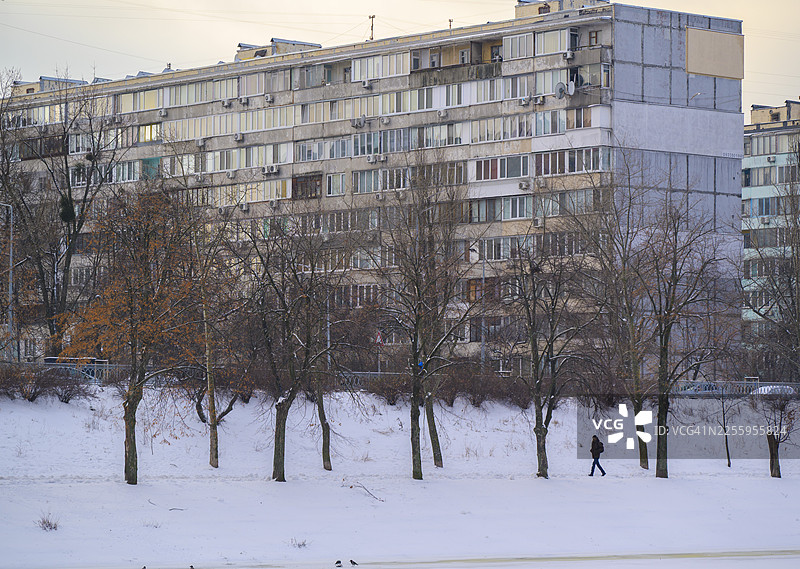 冬日城市里，一个人走在雪地小径上图片素材