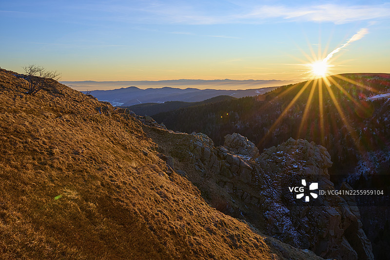阳光照射下的岩石边缘俯瞰广阔的山景，望向莱茵河谷，观景点，皮埃尔峡谷，马丁斯旺德，弗兰克塔尔，孚日山脉，法国图片素材
