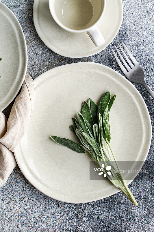 俯视下午茶餐桌摆设，点缀着新鲜的鼠尾草叶图片素材