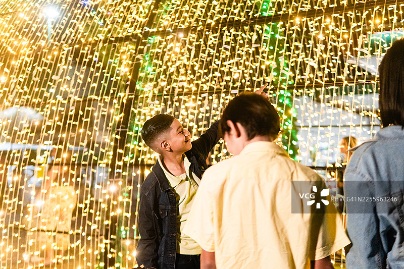 孩子们在夜市上享受明亮的串灯图片素材