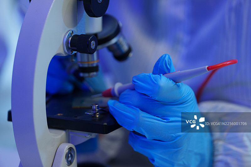 国际男女技术人员身着无菌服，在半导体制造工厂中使用显微镜工作（照片）图片素材