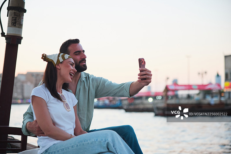 男子用智能手机与女友自拍图片素材