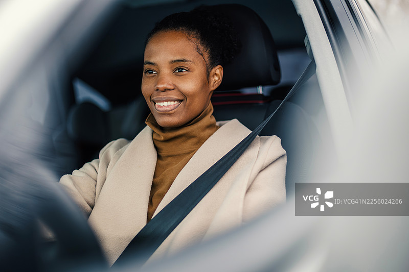 微笑的非裔美国女性在车内安全驾驶图片素材