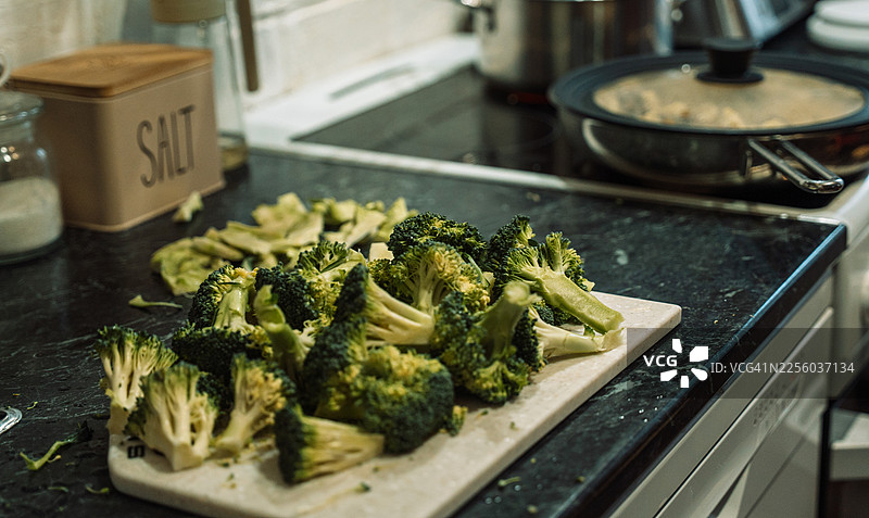 家庭厨房的砧板上的西兰花，备餐概念图片素材