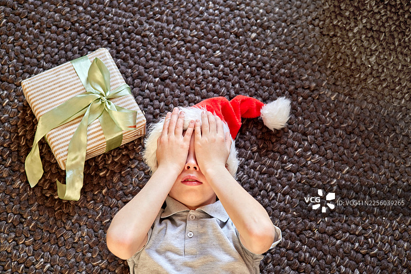 戴着圣诞帽的孩子期待圣诞礼物惊喜图片素材