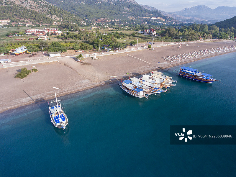安塔利亚阿德拉桑海滩上等待的旅游船只的航拍图图片素材