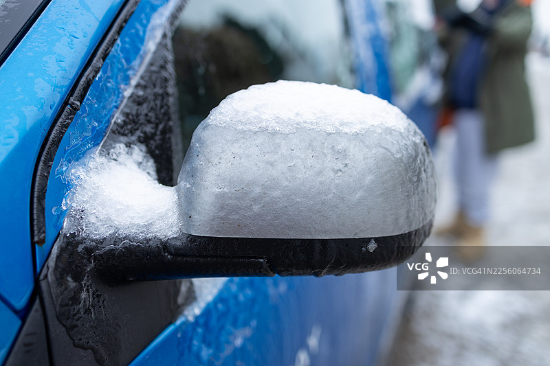 被厚冰和雪覆盖的汽车侧后视镜特写图片素材