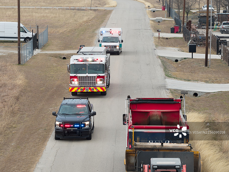 消防车和救护车在美国乡村的道路上行驶，有警车护送图片素材