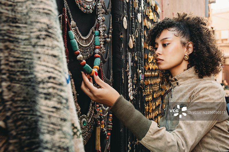 年轻女子在马拉喀什露天市场选购手工饰品图片素材