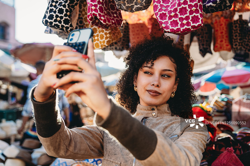 女子在马拉喀什市场用智能手机自拍图片素材