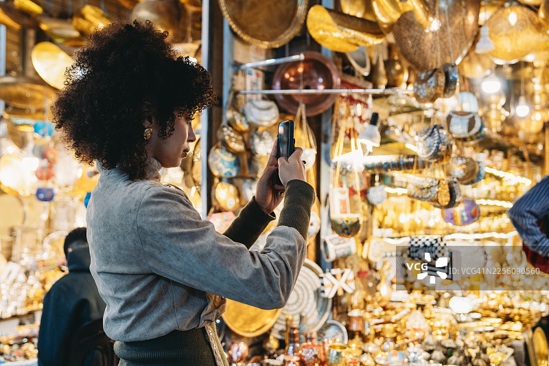 年轻女子在色彩缤纷的摩洛哥市集拍照图片素材