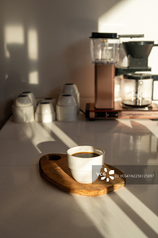 过滤咖啡的陶瓷杯，沐浴在自然光下图片素材
