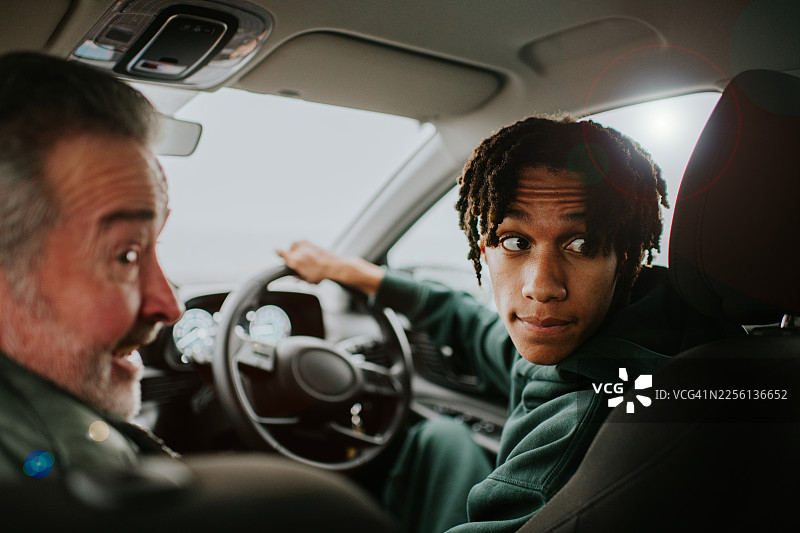 年轻男子在教练指导下仔细地倒车，进行驾驶课程图片素材