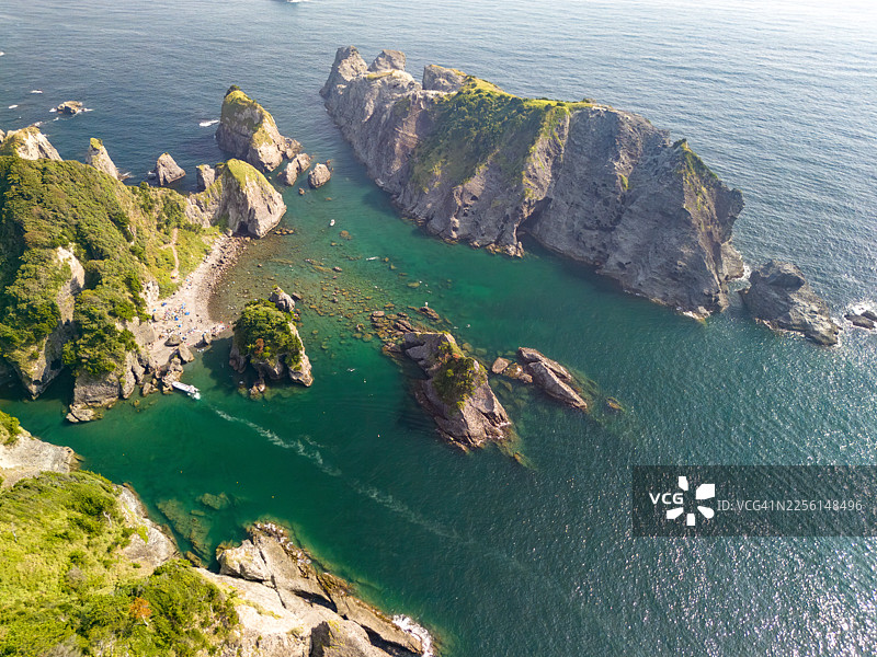 无人机视角拍摄的伊豆半岛尖端的平鹤海滩。海上可见大根岛和众多岩石海岸；陆侧可见中木港、爱彩岬和裕须惠公园。图片素材