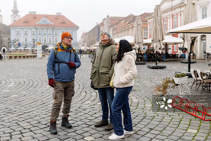 成熟的朋友们正在游览古老的欧洲城镇图片素材