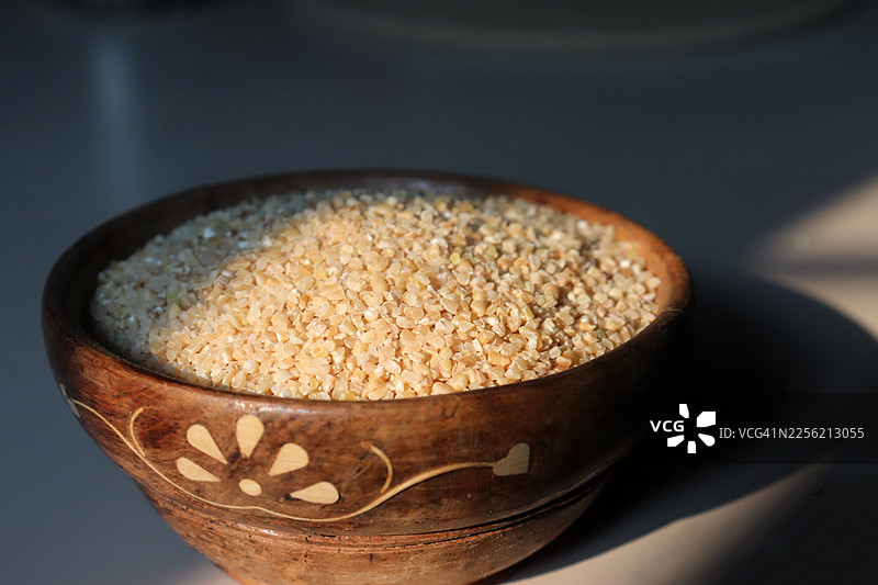 特写：碗中盛放的有机碎小麦（又称布格麦或达利亚麦），晨光下的静物。图片素材