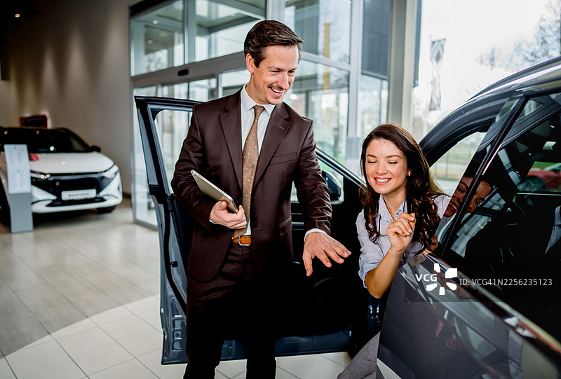 汽车销售员向客户展示车辆内部图片素材