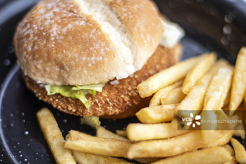 裹面包糠的炸鸡汉堡配薯条，快餐食品。图片素材