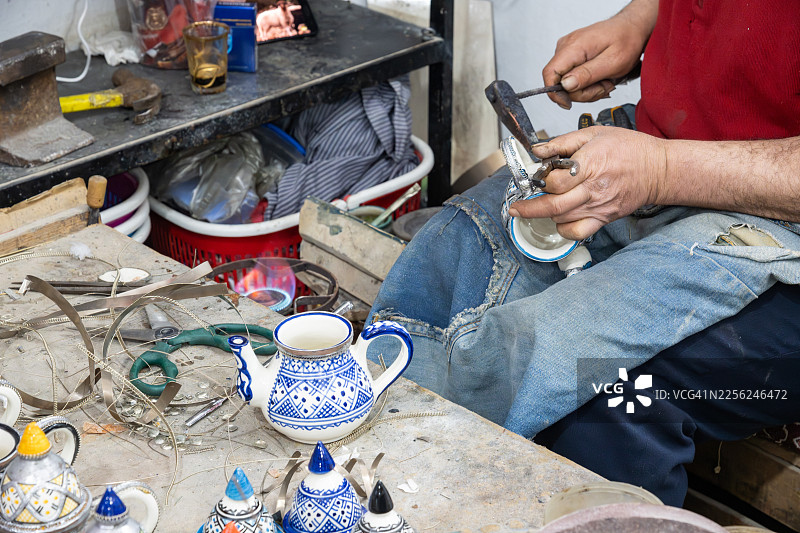 摩洛哥工匠在工作室制作茶壶金属配件图片素材