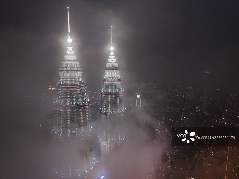 吉隆坡夜雾中灯火辉煌的国油双峰塔航拍图图片素材
