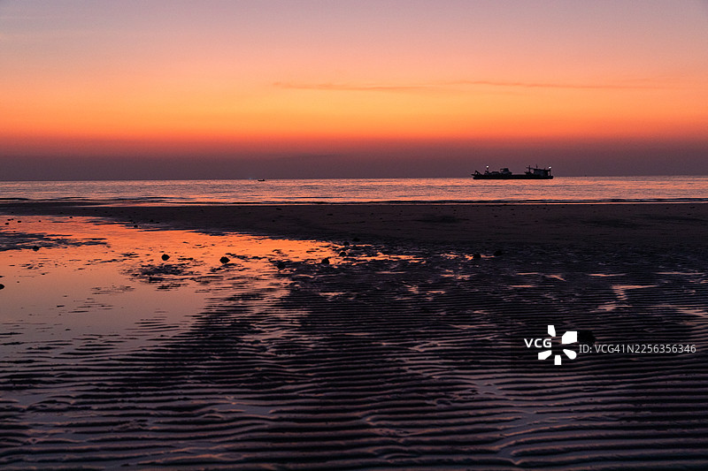戈公岛：戈公岛日落天空和低潮海滩的景色，岸边平静的海水有美丽的倒影。图片素材