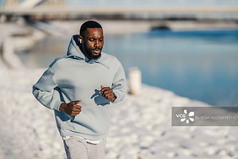 年轻黑人男性在冬日清晨锻炼跑步图片素材