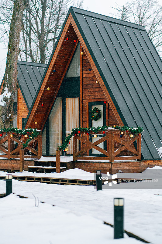 冬季雪景中装饰一新以迎接圣诞的A型框架小屋图片素材