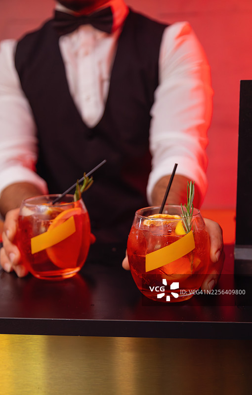 调酒师在吧台提供红色鸡尾酒图片素材