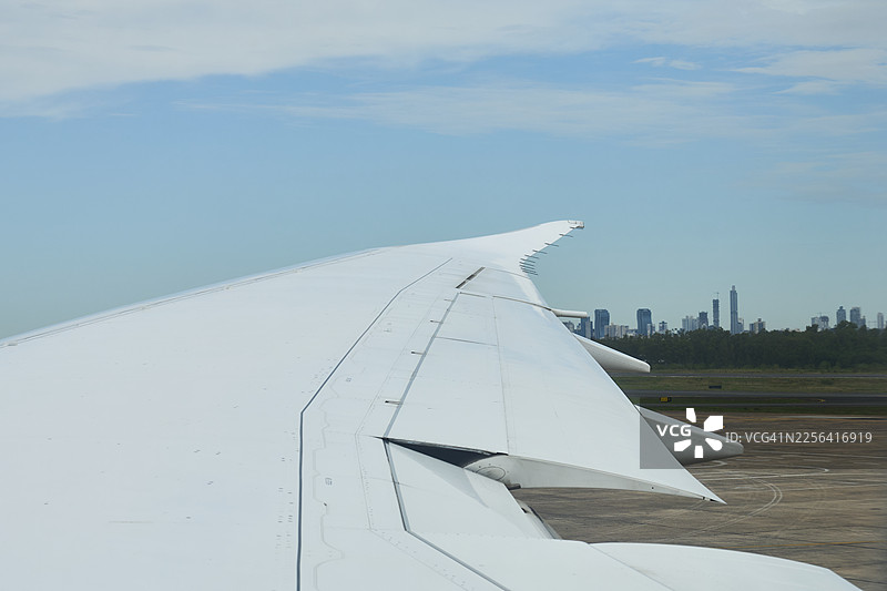 飞机机翼准备起飞，背景是亚松森天际线图片素材