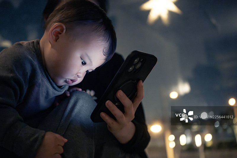 11个月大的婴儿和妈妈一起看手机屏幕图片素材