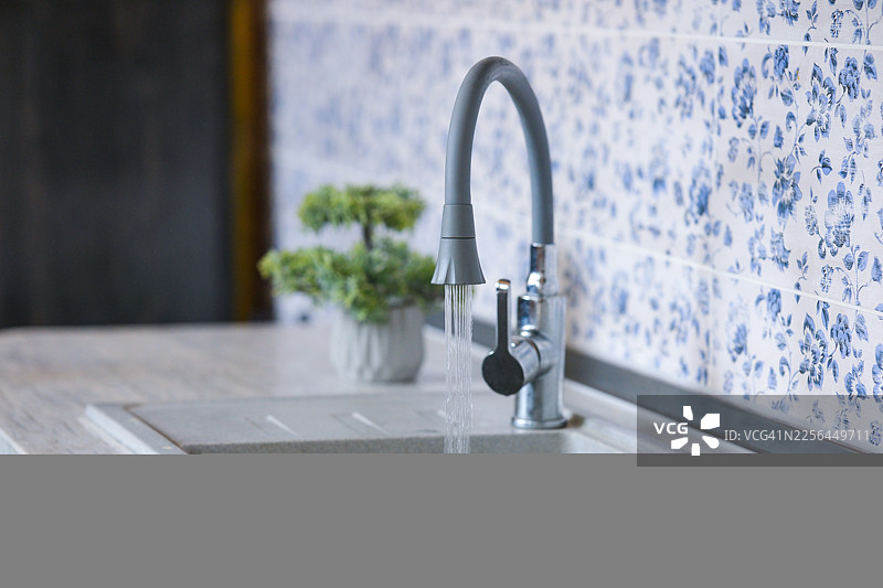 家中厨房水槽水龙头正在流出自来水图片素材