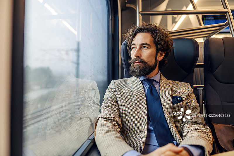 商务人士在火车旅途中欣赏窗外风景图片素材