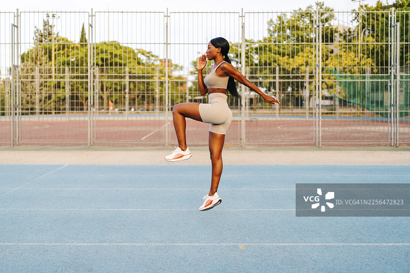 身着运动服的运动员在户外跑道上训练，进行跑步练习图片素材