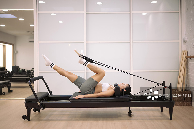 女性在室内使用普拉提器械进行健身和健康锻炼图片素材