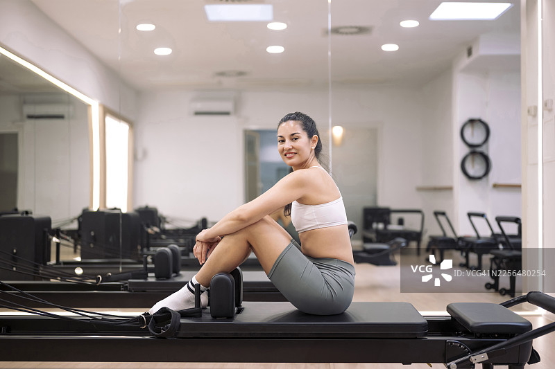 健身房教练在现代健身房的普拉提器械上放松图片素材