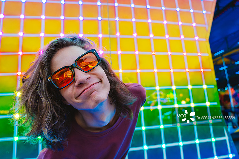 夜晚的游乐园里，霓虹闪烁，一个人面带微笑图片素材